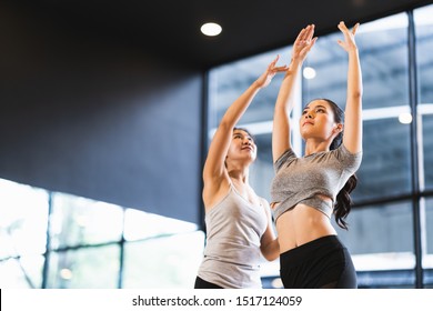 Beautiful Asian woman learning yoga pose with female instructor in yoga studio or health club. Sport exercise activity, gymnastics or ballet dancing class, or healthy people lifestyle concept - Powered by Shutterstock