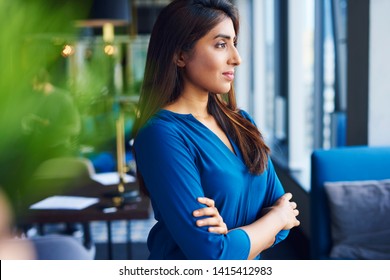 Beautiful Asian woman looking through window in the office