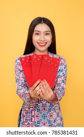 Beautiful asian woman on traditional festival costume Ao Dai holding lucky pocket money