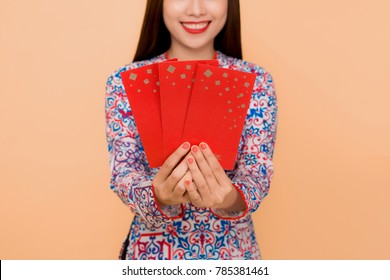 Beautiful asian woman on traditional festival costume Ao Dai holding lucky pocket money