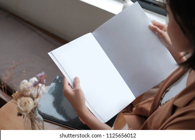 Beautiful Asian Woman Reading Magazine On Window Table