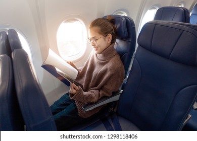 Beautiful Asian Woman Is Reading Magazine In Airplane 