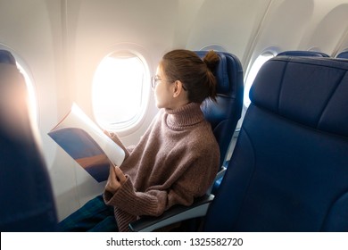 Beautiful Asian Woman Is Reading Magazine In Airplane 