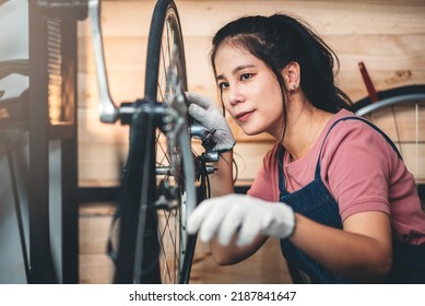Beautiful asian woman repairman girl ,bike maintenance with happy and replace a bike chain, self bike workshop at home. - Shutterstock ID 2187841647