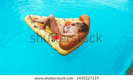Beautiful Asian woman in the sea swims on an inflatable ring and has fun on vacation. Girl in a bright swimsuit at the sea under the sunlight.