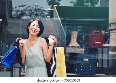 Beautiful Asian Woman With Shopping Bag In Front Of Outlet Mall.