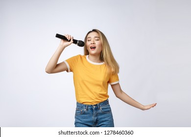 Beautiful Asian Woman Sing A Song To Microphone, Portrait Studio On White Background.