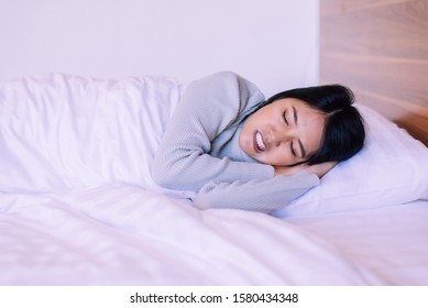 Beautiful asian woman sleeping on bed and grinding teeth,Female tiredness and stress