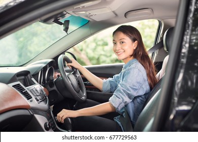 Beautiful Asian Woman Smiling And Enjoying Driving A Car And Hand Is About To Drive Into Gear On Road For Travel 