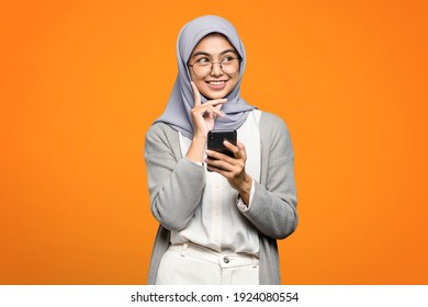 Beautiful Asian woman smiling and holding smartphone