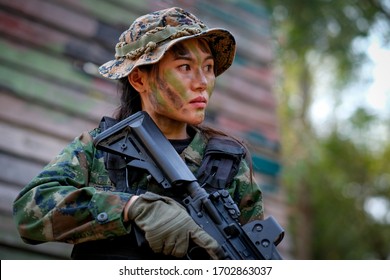 Beautiful Asian Woman Soldier Hold The Gun And Stand With Resting Position To Prepare For Fight In Battle Field.