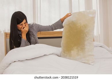 Beautiful asian woman suffers from a respiratory allergy caused by moldy pillows and yellow stains, foul smelling, pungent smell : Health care (allergic rhinitis) concept. - Shutterstock ID 2038121519