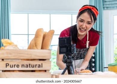 Beautiful Asian Woman Teaching How To Make Bread Bakery And Using The Camera To Record Live Online Social Media Vlogger Or Small Business Blogger Live Streaming Online, Live, Zoom.