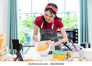 Beautiful Asian Woman Teaching How To Make Bread Bakery And Using The Camera To Record Live Online Social Media Vlogger Or Small Business Blogger Live Streaming Online, Live, Zoom.