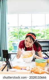 Beautiful Asian Woman Teaching How To Make Bread Bakery And Using The Camera To Record Live Online Social Media Vlogger Or Small Business Blogger Live Streaming Online, Live, Zoom.