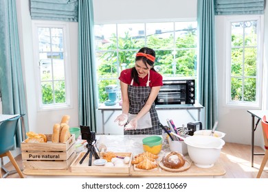 Beautiful Asian Woman Teaching How To Make Bread Bakery And Using The Camera To Record Live Online Social Media Vlogger Or Small Business Blogger Live Streaming Online, Live, Zoom.