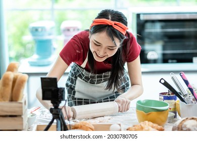 Beautiful Asian Woman Teaching How To Make Bread Bakery And Using The Camera To Record Live Online Social Media Vlogger Or Small Business Blogger Live Streaming Online, Live, Zoom.