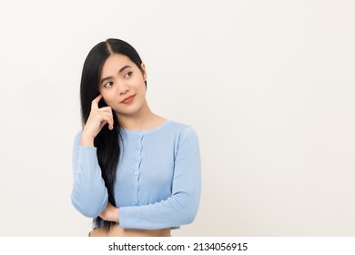 Beautiful Asian Woman Thinking. Smiling Female Standing Pose On Isolated White Background. Attractive Teenager Girl Around 25 Looking At Empty Space For Text Feeling Excited And Thinking.