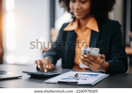 Beautiful Asian woman using laptop and tablet while sitting at her working place. Concentrated at officework.