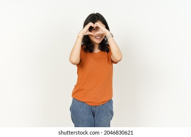 Beautiful Asian Woman Wearing Orange Color T-Shirt Make And Showing Love Heart Hand Sign Isolated On White Background