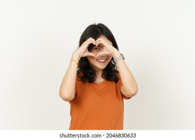 Beautiful Asian Woman Wearing Orange Color T-Shirt Make And Showing Love Heart Hand Sign Isolated On White Background