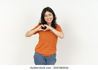 Beautiful Asian Woman Wearing Orange Color T-Shirt Make And Showing Love Heart Hand Sign Isolated On White Background