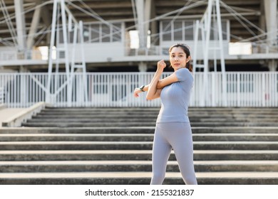 Beautiful female athlete stretching before workout indoors. Sport