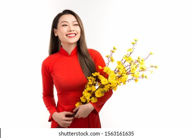 Beautiful Asian woman wearing Vietnam traditional Ao dai holding peach flower in Tet holidays.