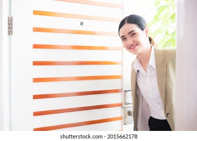 Beautiful Asian Woman Wearing Work Clothes She Was Smiling, Opening The Door To Enter The House Or Room.