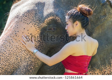 Beautiful Asian Woman wears thai dress with her elephant
