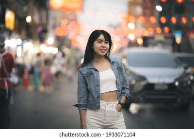 Beautiful Asian woman who has long hair travels to the festival at Yaowarat Chinatown in Thailand. Street photography of traveler woman at night.