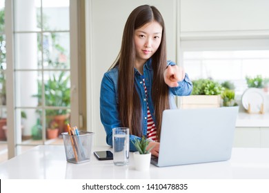 Beautiful Asian Woman Working Using Computer Laptop Pointing With Finger To The Camera And To You, Hand Sign, Positive And Confident Gesture From The Front