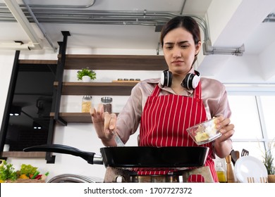 Beautiful Asian Women Are Cooking Breakfast In The Kitchen.
As She Put The Butter In The Pan, She Was Afraid That The Butter Would Bounce Off The Woman Modern Kitchen Concept.