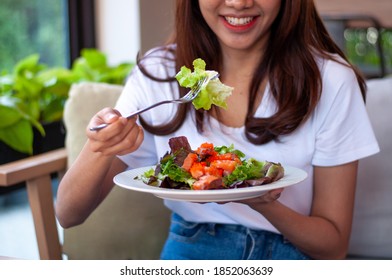 Beautiful Asian Women Are Enjoying Eating Salad With Salmon To Lose Weight. Healthy Young Woman Eating Vegetable Salad. Dieting , Healthy Food Concepts.