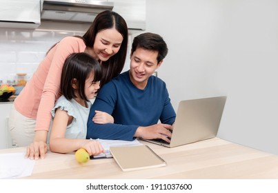 Beautiful Asian Women Lovely Girl Looking At The Laptop Screen Of Handsome Men Working Online On The Desk At Home It's A New Normal Life For The Family.