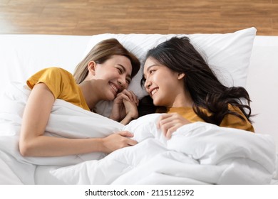 Beautiful Asian Young Lesbian LGBTQ Couple Or Friends Lying On Bed Looking Together Smile And Relax With Love.Happiness LGBT Couple Woman Spending Time Together At Home. LGBTQ Pride Month Concept