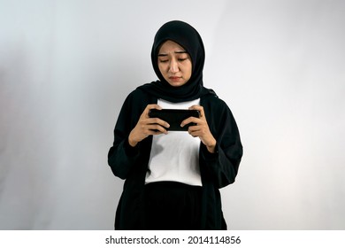 Beautiful Asian Young Muslim Woman Playing Game, Lost Playing Game, Holding Smartphone, Isolated On Gray Background