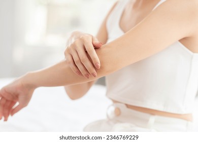 Beautiful Asian young woman apply cream or lotion on her arm for protect dry skin for moisturizing on skin. Healthy skin of young female doing self care at home. Woman self care concept - Shutterstock ID 2346769229