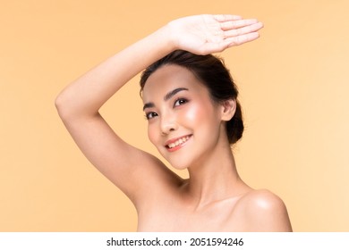 Beautiful Asian young woman hand up cover face protect sun light and UV smile with clean fresh skin Happiness and cheerful.isolated on Beige background.Beauty Cosmetics and Facial treatment Concept