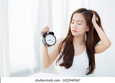 Beautiful Asian Young Woman Wake Up In Morning Annoyed Alarm Clock Holding Hand, Girl Hurry Wake Late With Appointment, Lifestyle Concept.