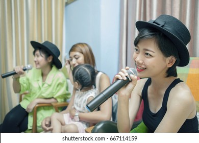 Beautiful Asian Younger Woman Singing Karaoke Song At Home ,family Relaxing And Happy Time 