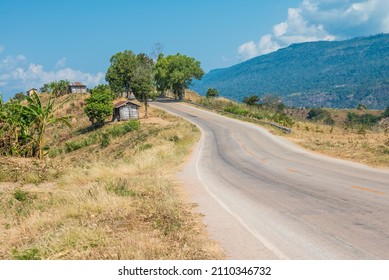 Beautiful Asphalt Country Road Side On The Green Mountain With Blue Sky Background In Sunny Day, Phetchabun Thailand. Road Trip, Travel Holiday Or Transportation Concept.