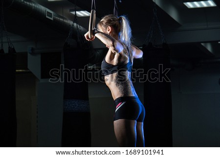 Similar – Image, Stock Photo Rear view portrait of one young middle age athletic woman at crossfit training, exercising with trx suspension fitness straps over dark background