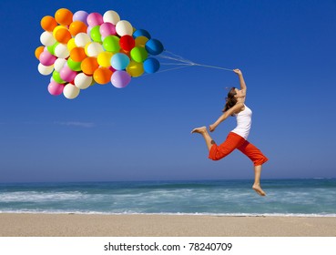 Beautiful and athletic girl with colorful balloons jumping on the beach - Powered by Shutterstock