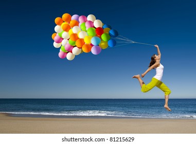 Beautiful and athletic girl with colorful balloons jumping on the beach - Powered by Shutterstock