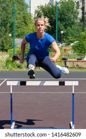 A Beautiful And Athletic Girl Is Running Hurdles In The Stadium Porttait