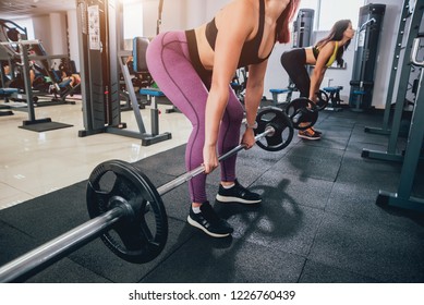 Beautiful athletic young women making exercise at the gym. Young woman with muscular body. Fitness concept. - Shutterstock ID 1226760439