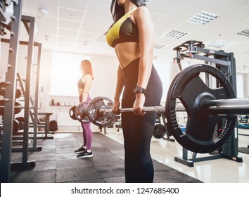 Beautiful athletic young women making exercise at the gym. Young woman with muscular body. Fitness concept. - Shutterstock ID 1247685400