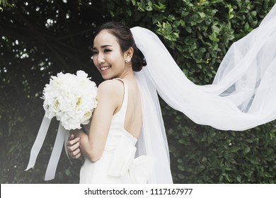 Beautiful Attractive Asian bride wearing wedding dress smile and holding bouquet,Feeling so proud and happiness in wedding day,Vintage Tone
