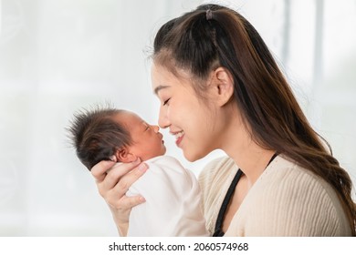 Beautiful Attractive Asian Mom Holding Her Baby Newborn In Hand And Kissing On Baby Nose Sweet And Lovely.Happy Mother And Infant Baby Looking Together Smile With Love.Mother And Baby Newborn Concept